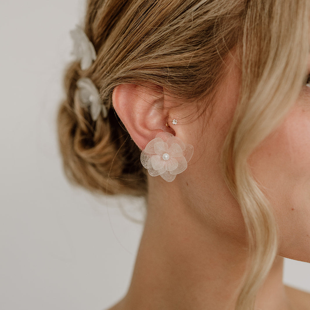 Braut Ohrstecker Carry klein aus 925 Sterlingsilber 18K vergoldet mit weißen Blüten aus biobasiertem, nachhaltigen Material und veganer Perle, am Model getragen