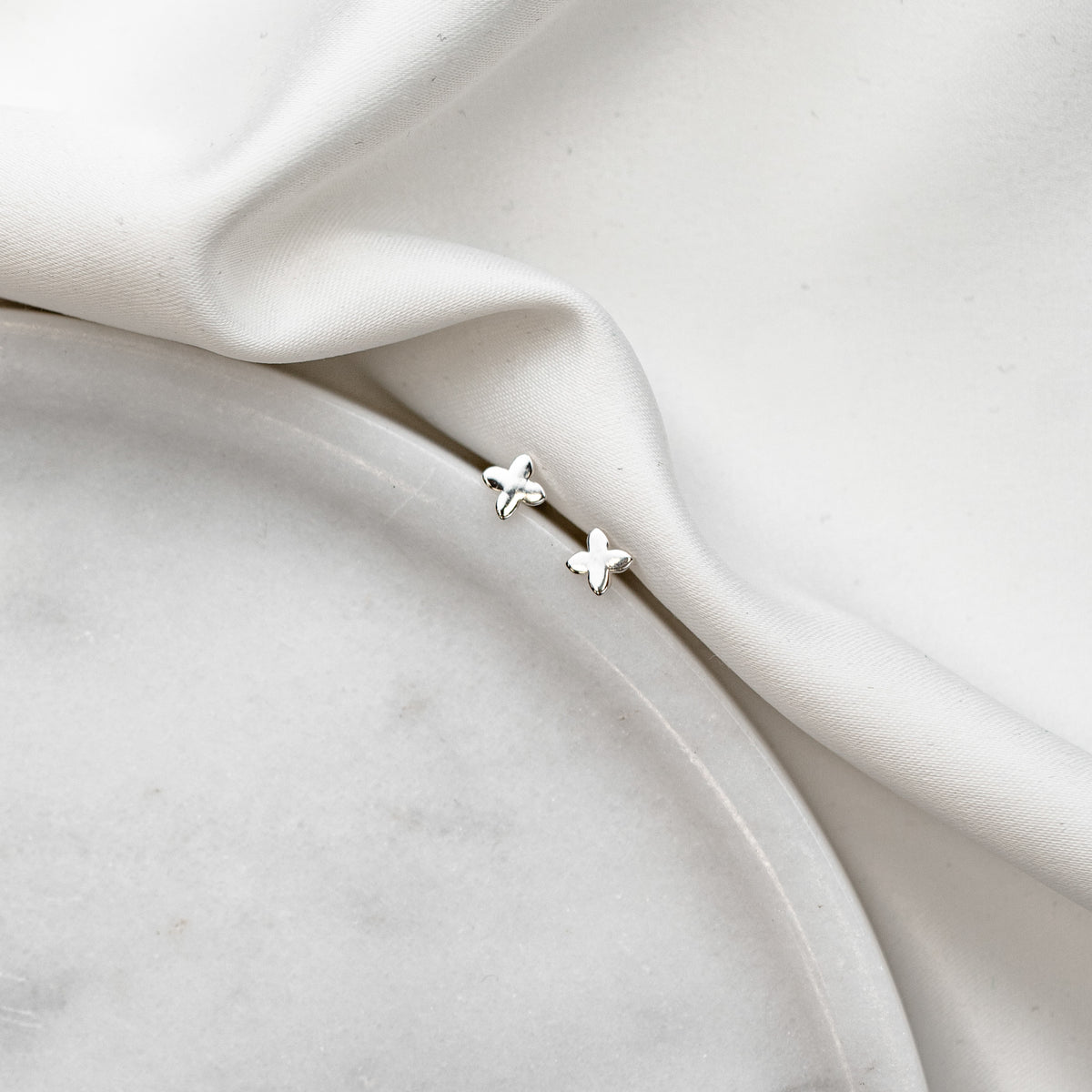Braut Ohrstecker Paola in Sternform aus 925 Sterlingsilber, liegend auf Marmorplatte