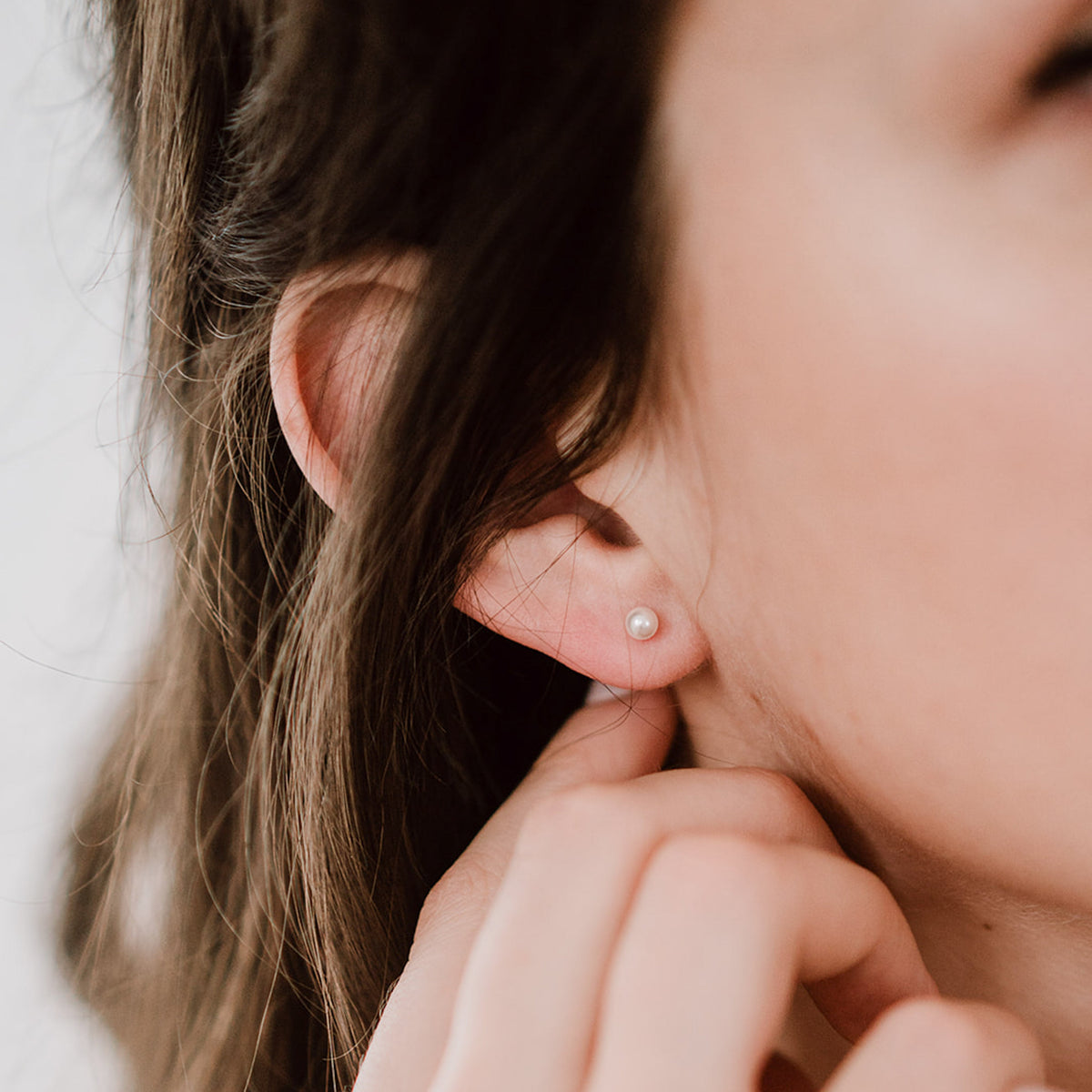 Perlenstecker Perla 4mm aus 925 Sterlingsilber 18K vergoldet mit veganer Perle, am Model getragen