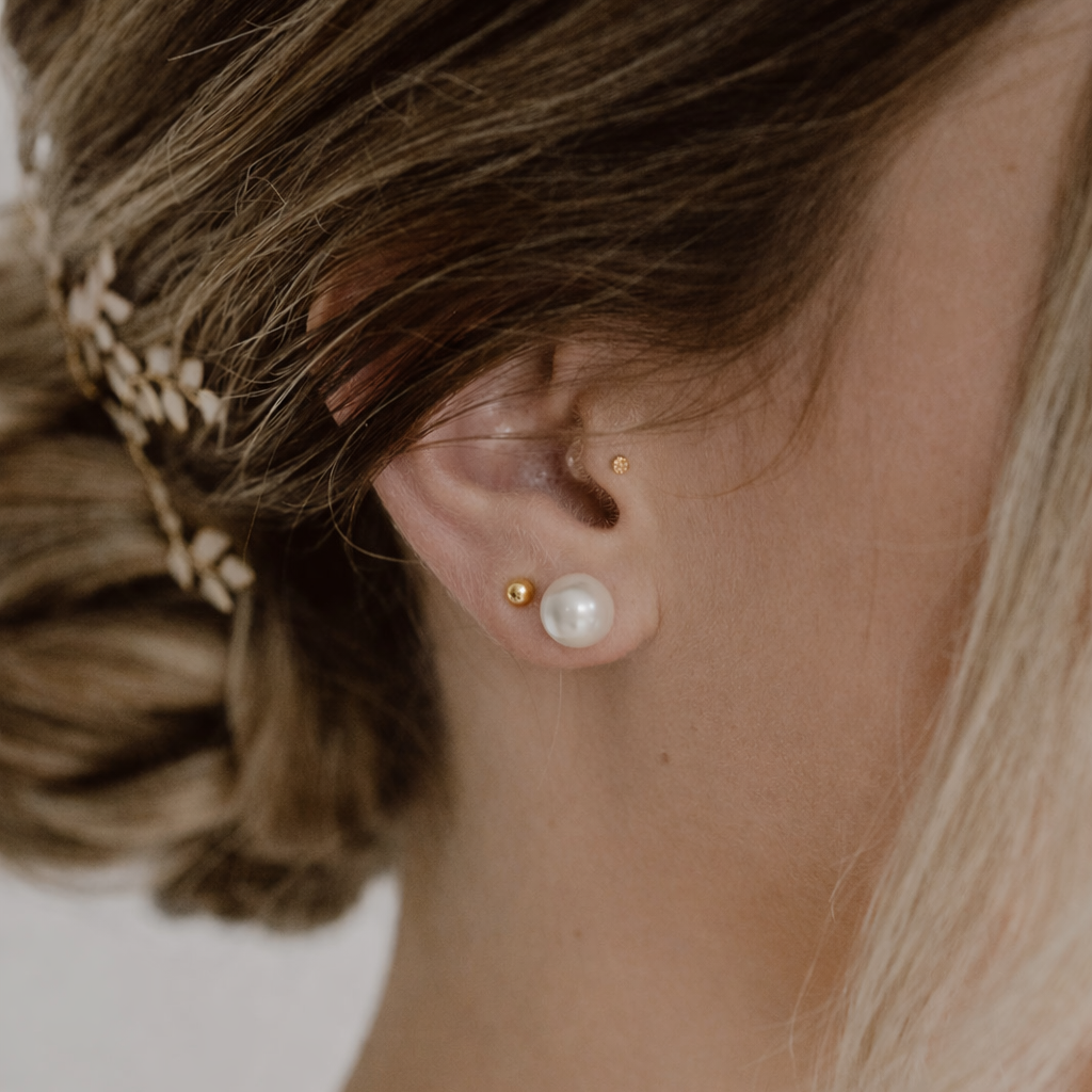 Braut Ohrstecker Perla aus 925 Sterlingsilber 18K vergoldet mit runder weißer 8mm Perle, Nahaufnahme am Ohr