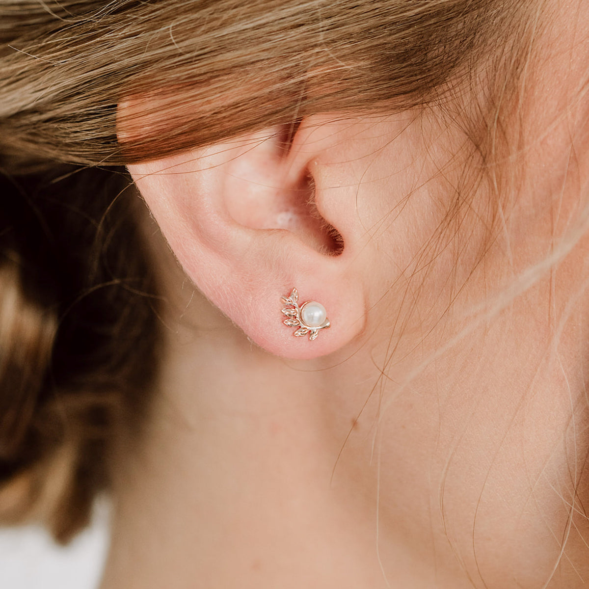 Braut Ohrstecker Resi aus 925 Sterlingsilber 18K rosévergoldet mit Blättern und veganer Perle, Nahaufnahme am Ohr