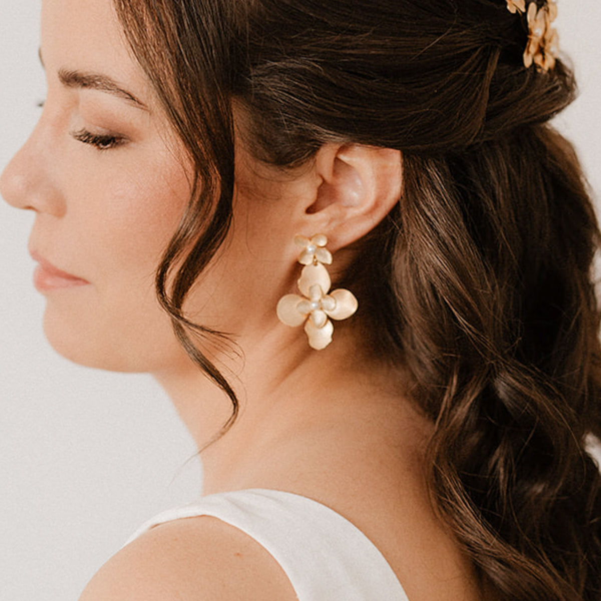 Statement Ohrringe Vika, eine große Blüte hängt an einem kleinen Blütenstecker mit veganen Perlen in 925 Sterlingsilber 18 K vergoldet, in Nahaufnahme am Model