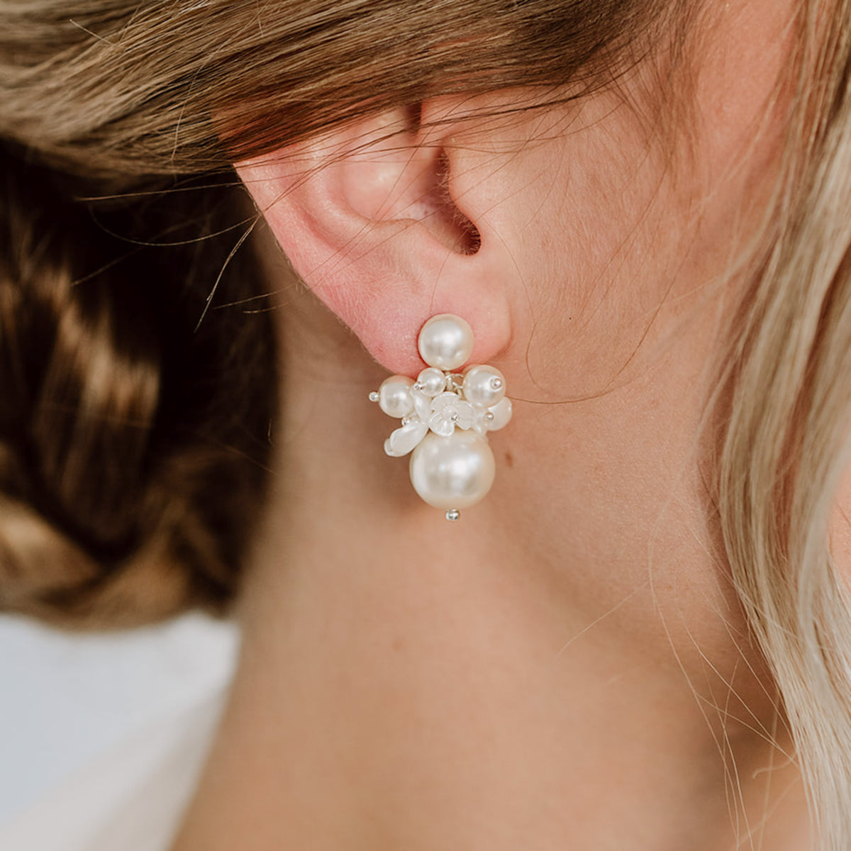Braut Ohrringe Sofie in 925 Sterlingsilber 18K vergoldet mit unterschiedlich großen, veganen Perlen und Blüten, Nahaufnahme am Ohr